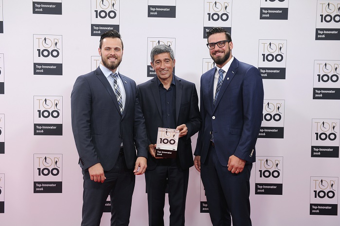 Ranga Yogeshwar presents the award to Benjamin (left) and Sebastian Mayer (right). © KD Busch/compamedia